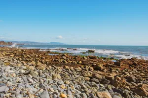 a rocky beach with a body of water in the background jigsaw puzzle