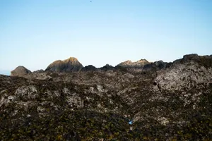 Rugged, dark rocks under a clear blue sky. jigsaw puzzle