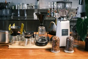 A wooden table topped with coffee cups and a blender jigsaw puzzle