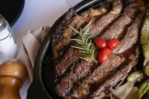 grilled meat with tomato and green vegetable on black pan jigsaw puzzle