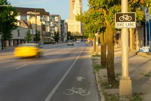 A city street with a bike lane and a clock tower in the background jigsaw puzzle