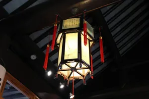 Traditional chinese lantern with red tassels hangs from dark ceiling. jigsaw puzzle