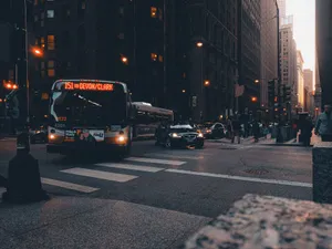 Urban scene with bus and traffic in a city setting at twilight, highlighting urban life. jigsaw puzzle