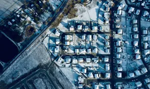 Aerial photograph showcasing a winter landscape of a snowy residential neighborhood. jigsaw puzzle
