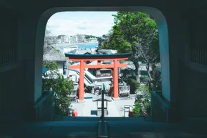 A picturesque scene featuring a Torii gate with cityscape and greenery in the background. jigsaw puzzle
