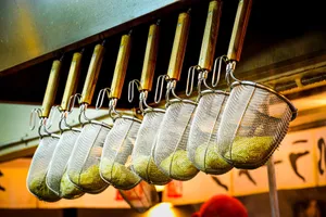 A close-up of noodle strainers hanging in a Japanese ramen restaurant, showcasing culinary tools. jigsaw puzzle