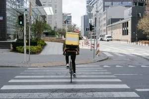 Cyclist with thermal bag crossing street in downtown Warsaw, Poland. jigsaw puzzle