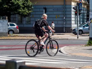 A man biking across a city street intersection on a sunny day. Urban commuting lifestyle. jigsaw puzzle