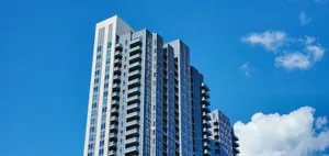 Tall modern high-rise building set against a vibrant clear blue sky, showcasing contemporary architecture. jigsaw puzzle