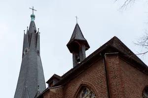 Gothic church steeples in Düsseldorf with intricate brickwork against a cloudy sky backdrop. jigsaw puzzle