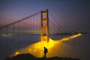 A person silhouetted in front of the Golden Gate Bridge enveloped in evening fog. jigsaw puzzle