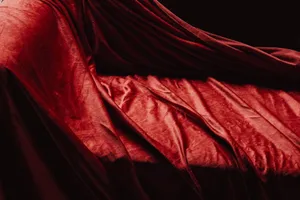 Rich texture of luxurious red velvet fabric draped elegantly creating soft shadows and highlights. jigsaw puzzle