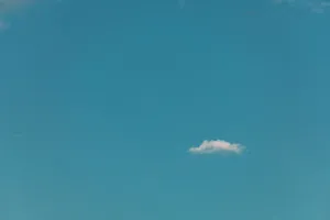 A tranquil blue sky featuring a single white cloud, epitomizing simplicity and serenity. jigsaw puzzle