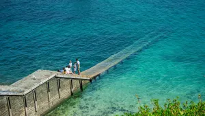 People on a wooden pier over clear turquoise water jigsaw puzzle