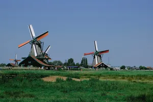 Dutch windmills with orange sails against a clear blue sky. jigsaw puzzle