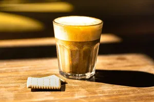 a glass of beer next to a white cookie jigsaw puzzle
